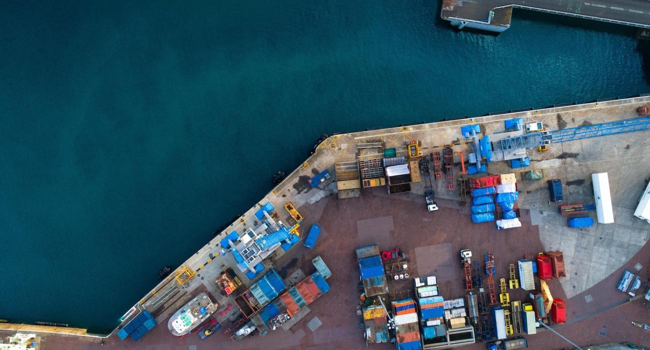 Aerial view of water and dock covered in shipping containers